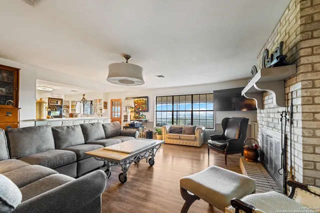 a living room with furniture fireplace and a large window