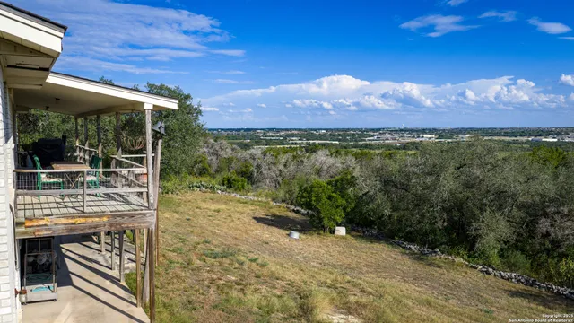 a view of a patio with a table chairs and a floor to ceiling window