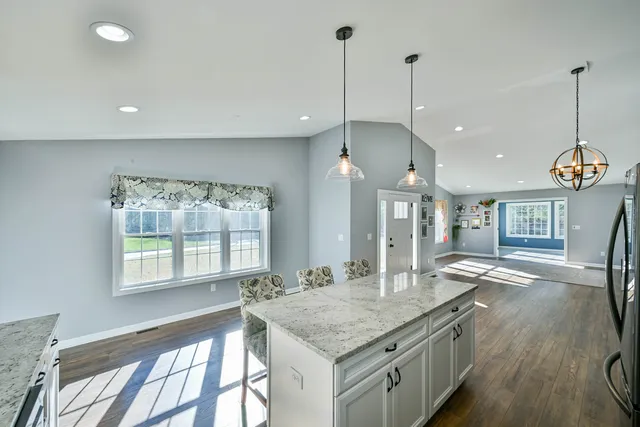 a kitchen with stainless steel appliances granite countertop a sink a stove and a wooden floor