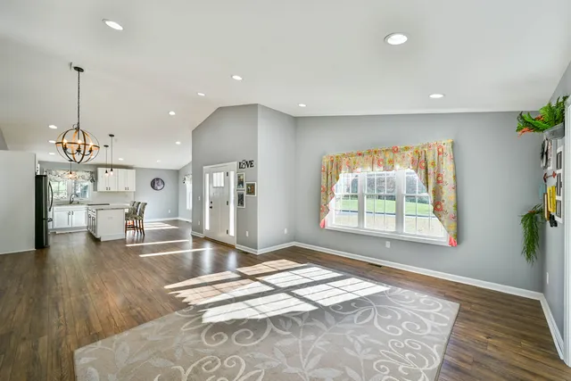 a living room with kitchen island furniture and a chandelier
