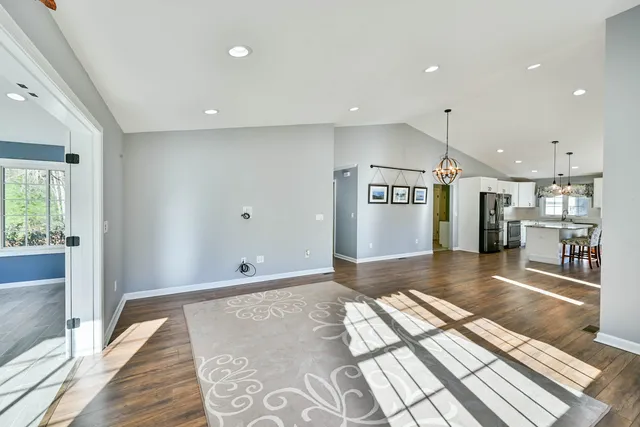 a view of a living room with a rug floor to ceiling window and wooden floor