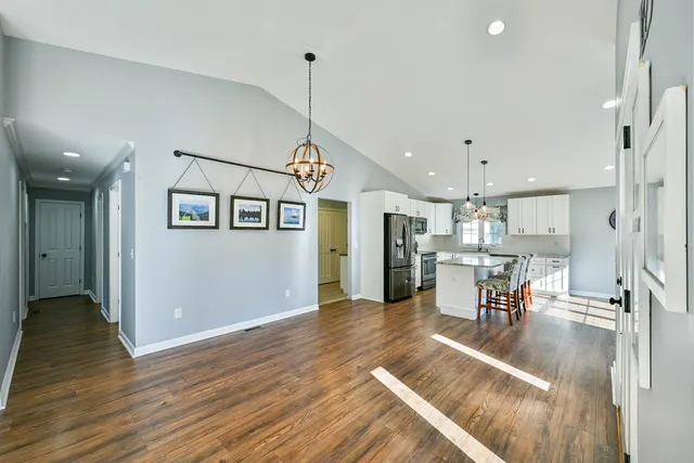 a view of a dining room and livingroom with furniture wooden floor a chandelier