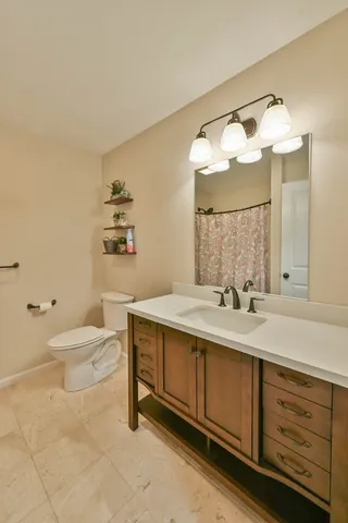 a bathroom with a sink vanity mirror and toilet