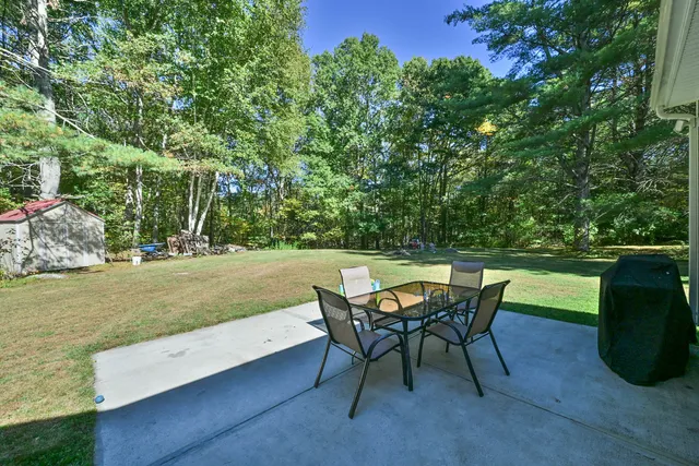 a view of a backyard with table and chairs