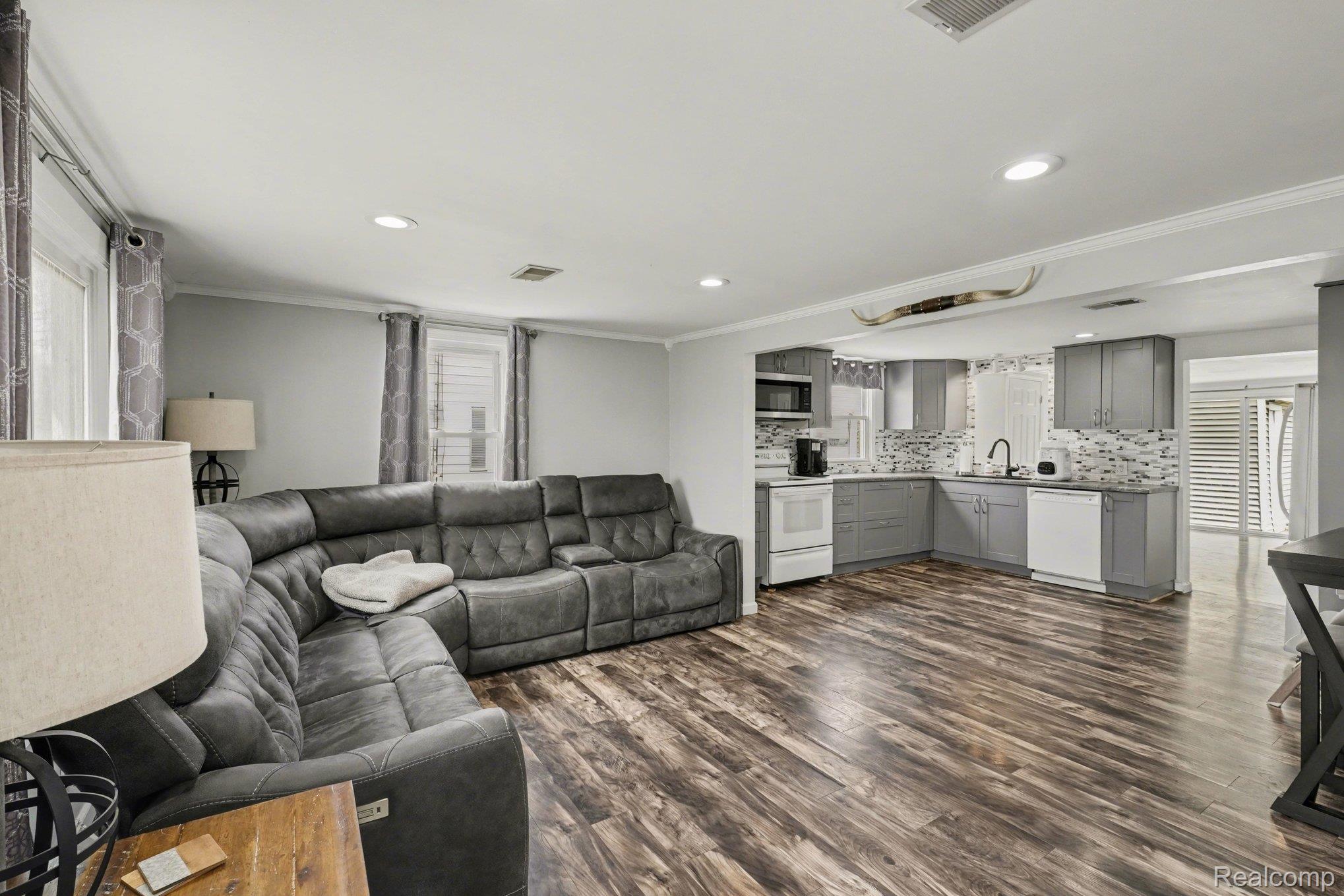 16485 Jennings Road Fenton, MI 48430 - Photo 9 of 27 Living area with dark wood-type flooring, crown molding, and recessed lighting