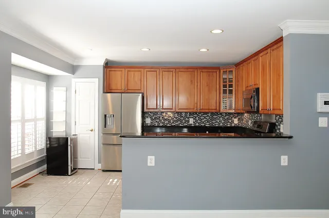 a kitchen with stainless steel appliances granite countertop a refrigerator and a stove