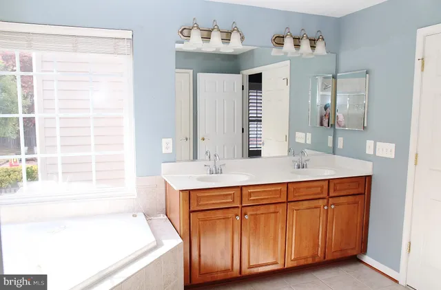 a bathroom with a tub sink and mirror