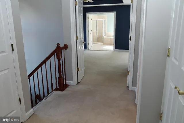 a view of a hallway with a livingroom and stairs