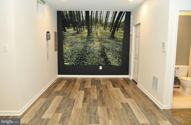 a view of empty room with wooden floor