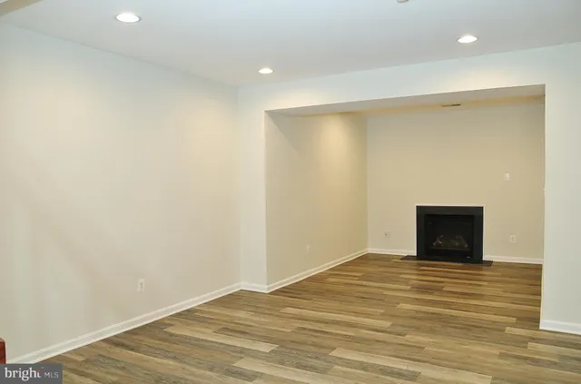 a view of room with wooden floor and white walls