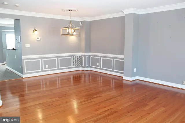a big room with wooden floor a ceiling fan and window