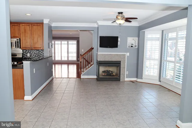 a view of a livingroom with a fireplace a chandelier and windows