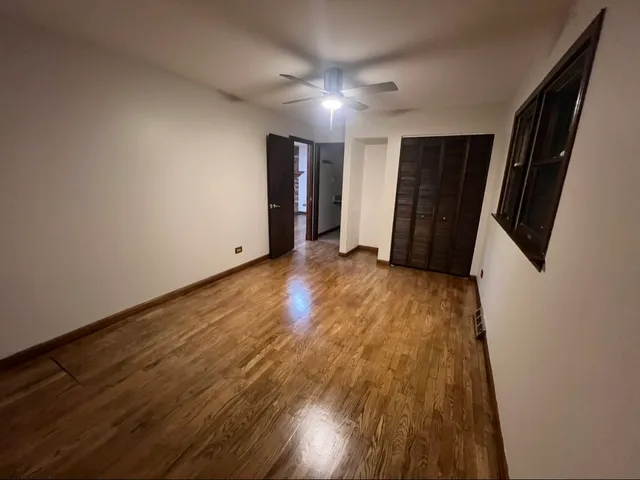 an empty room with stairs and wooden floor