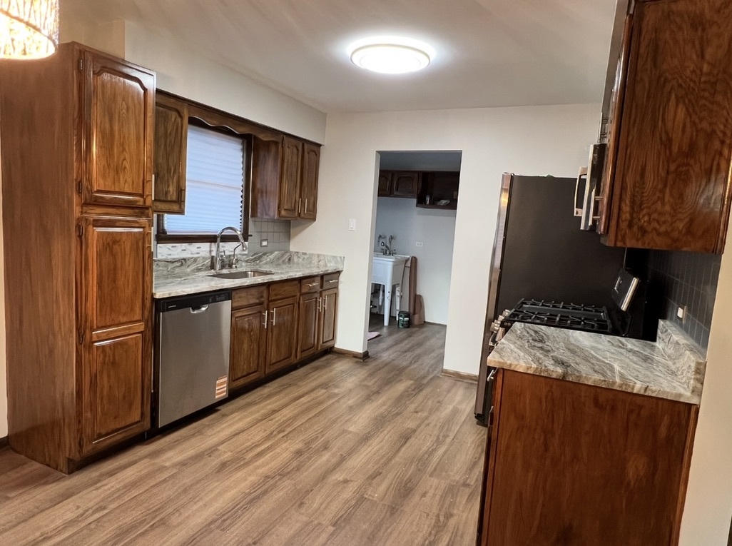 3529 Carpenter Street Steger, IL 60475 - Photo 3 of 20 a kitchen with stainless steel appliances granite countertop wooden cabinets a refrigerator a sink a stove a microwave and wooden floors