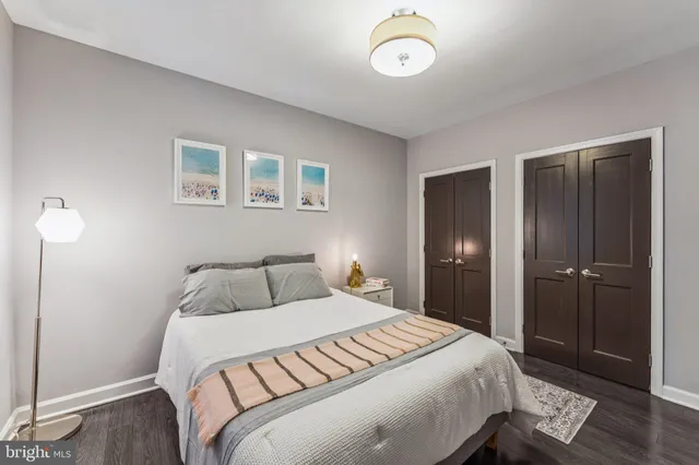 a bedroom with a large bed and wooden floor