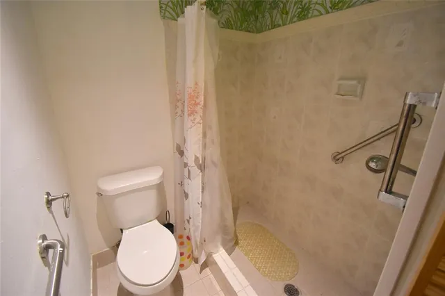 a white toilet sitting next to a shower