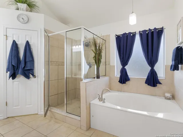 a bathroom with a bathtub a shower a sink and a window