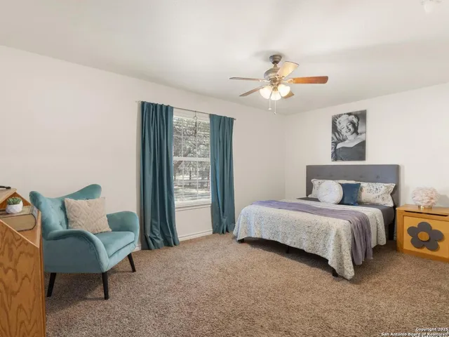 a spacious bedroom with a bed and a chandelier