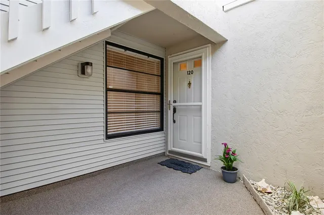 a view of a house with a potted plant and floor to ceiling window