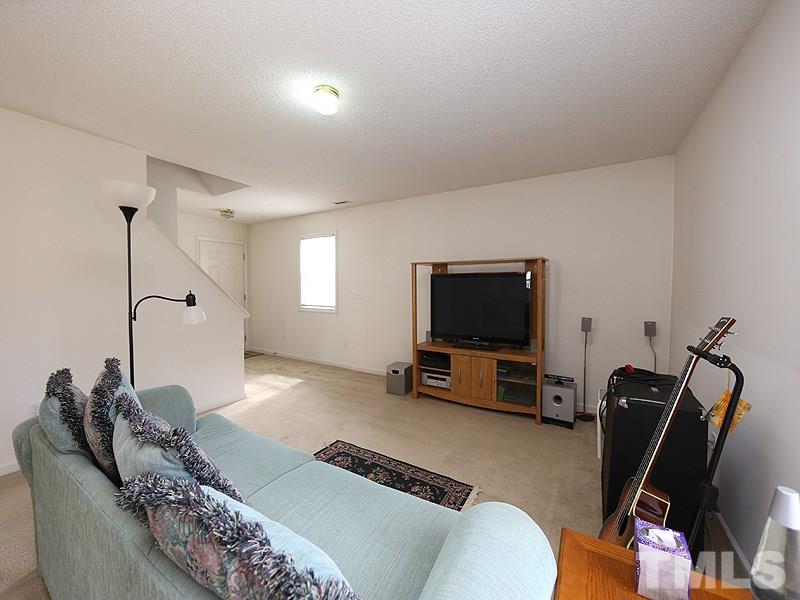 4205 Toccopola Street Raleigh, NC 27604 - Photo 11 of 24 a living room with furniture and a flat screen tv
