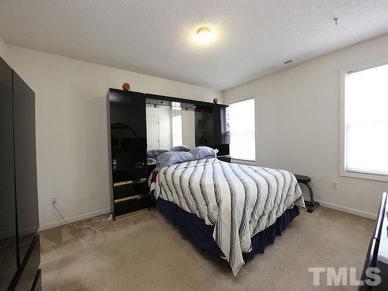 4205 Toccopola Street Raleigh, NC 27604 - Photo 16 of 24 a bed sitting in a spacious bedroom next to a window and a larger closet