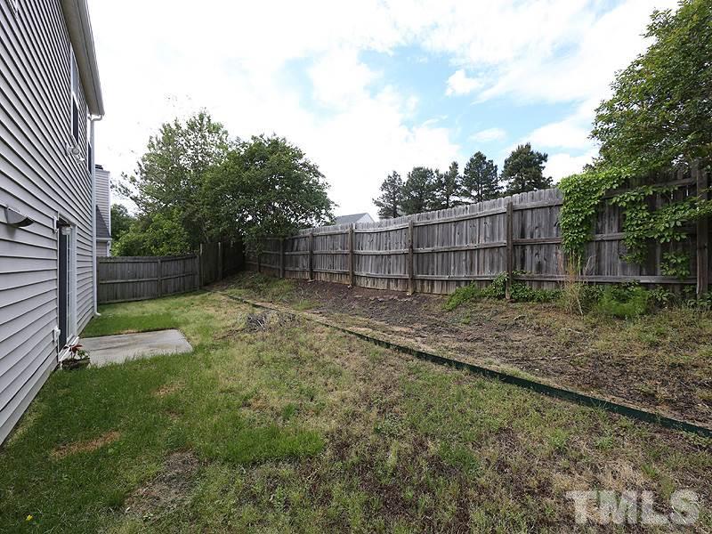 4205 Toccopola Street Raleigh, NC 27604 - Photo 21 of 24 a view of a backyard with a trees and wooden fence