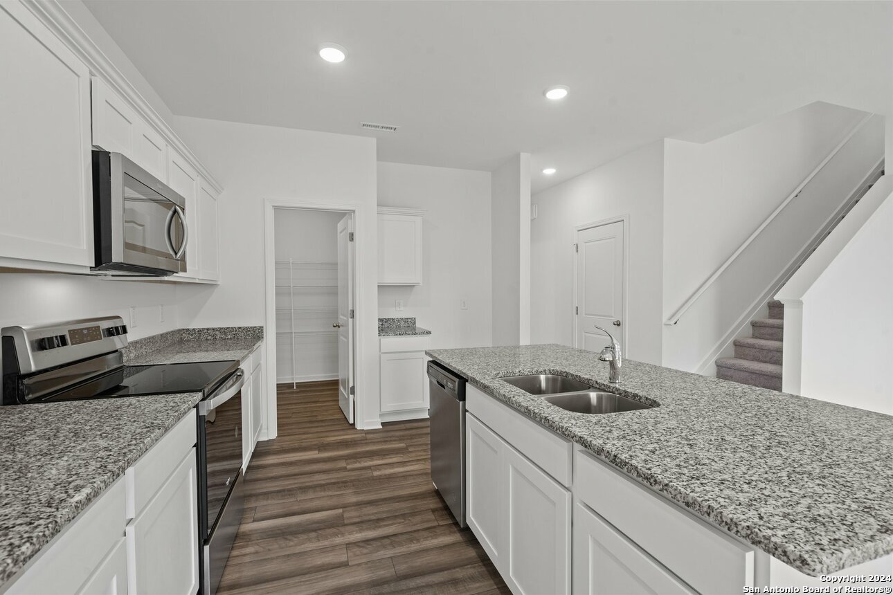 1428 Almeda Road Seguin, TX 78155 - Photo 6 of 17 a kitchen with stainless steel appliances granite countertop a sink stove and refrigerator