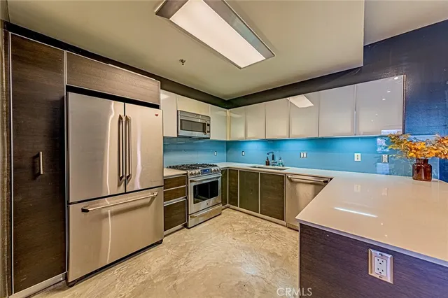 a kitchen with granite countertop a refrigerator and a stove top oven