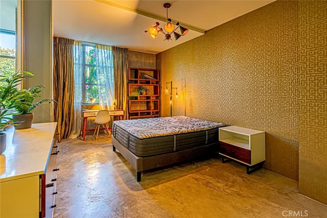 a bedroom with a bed and a potted plant on the dresser