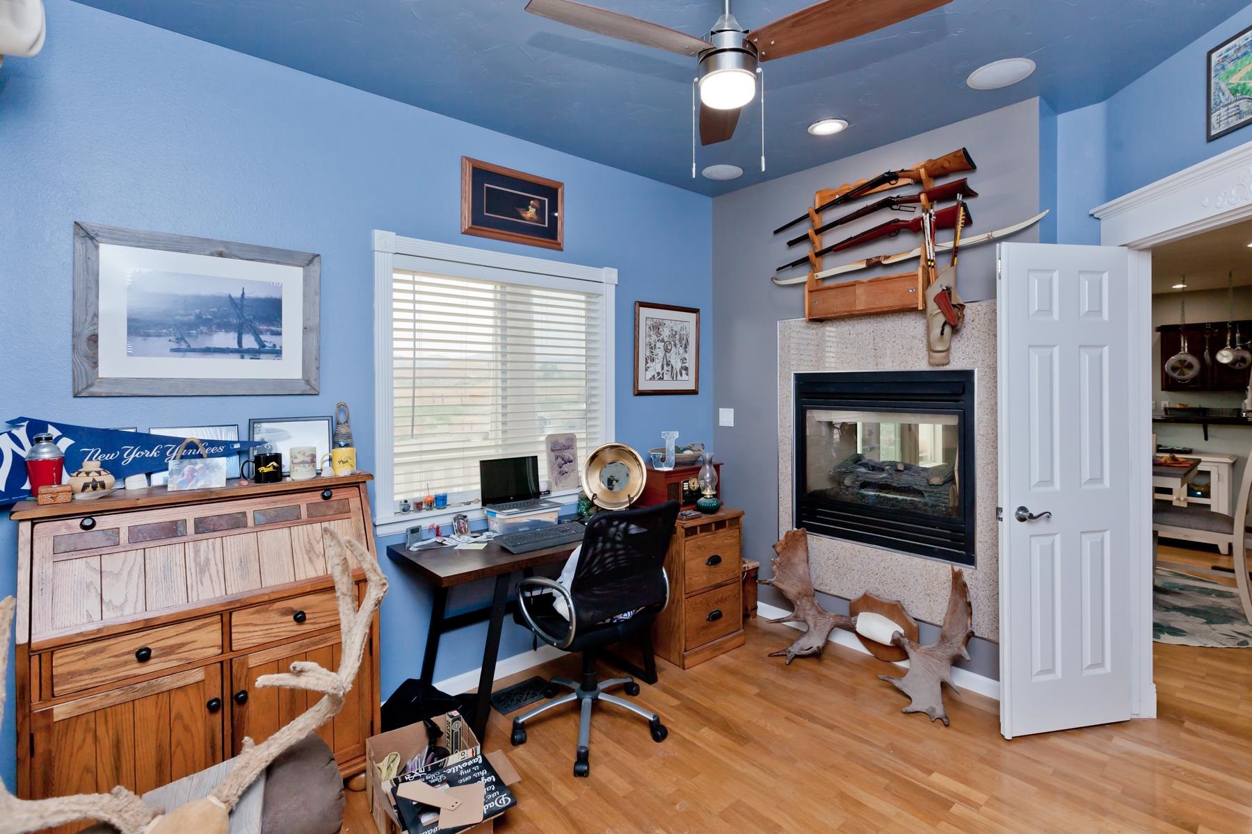 1815 O Road Fruita, CO 81521 - Photo 23 of 42 a work room with furniture a flat screen tv and a fireplace