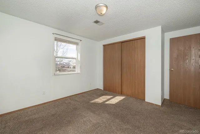 an empty room with windows and closet