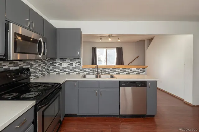 a kitchen with stainless steel appliances granite countertop a sink stove and microwave