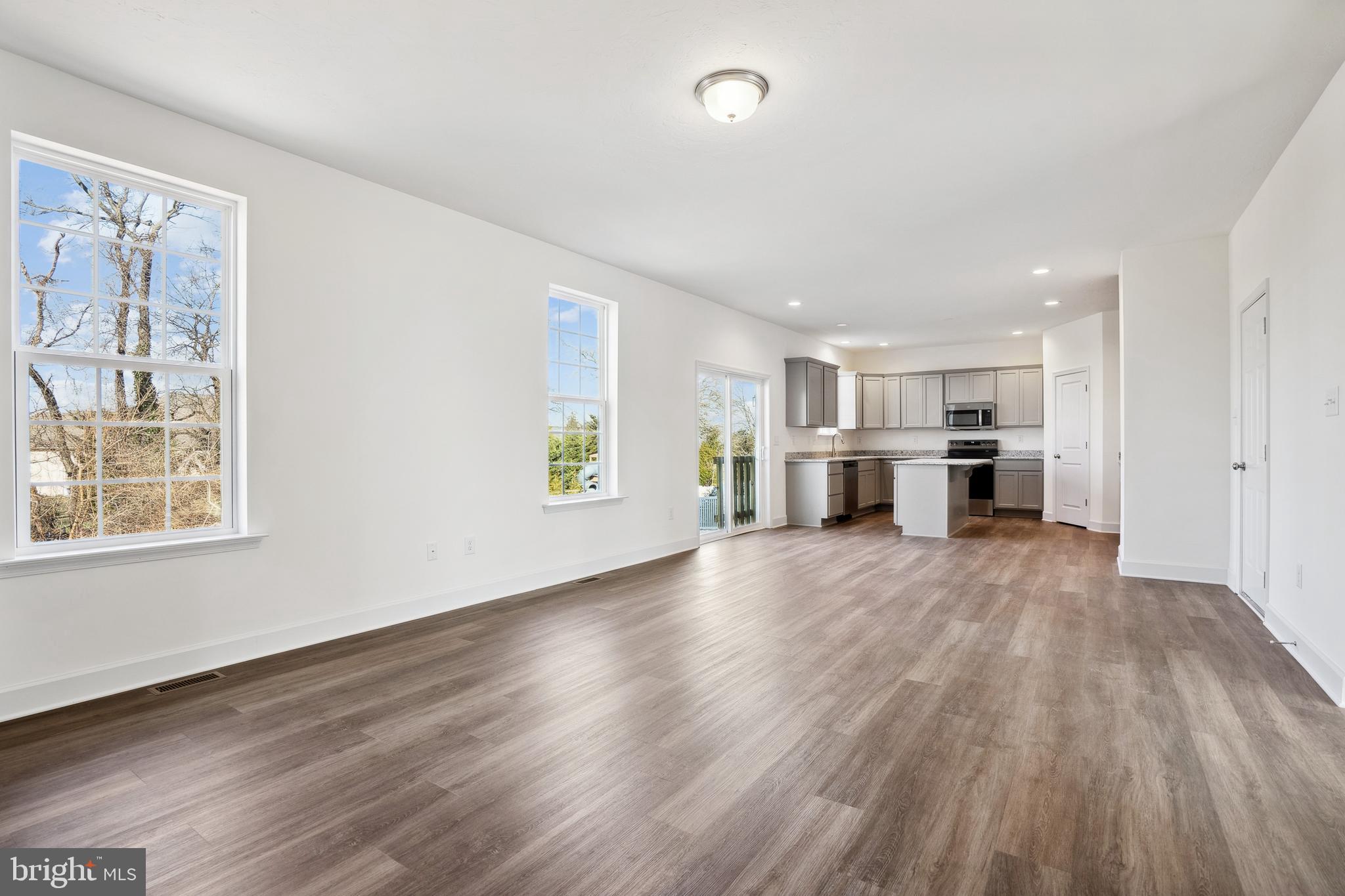 65 Eagle Drive Hanover, PA 17331 - Photo 9 of 26 an empty room with wooden floor kitchen view and windows