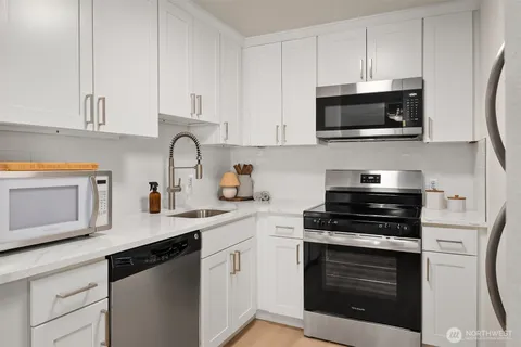 a kitchen with cabinets stainless steel appliances and a sink