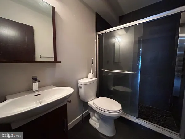 a bathroom with a toilet a sink and mirror