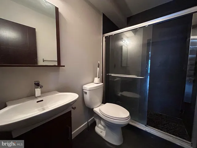 a bathroom with a toilet a sink and mirror