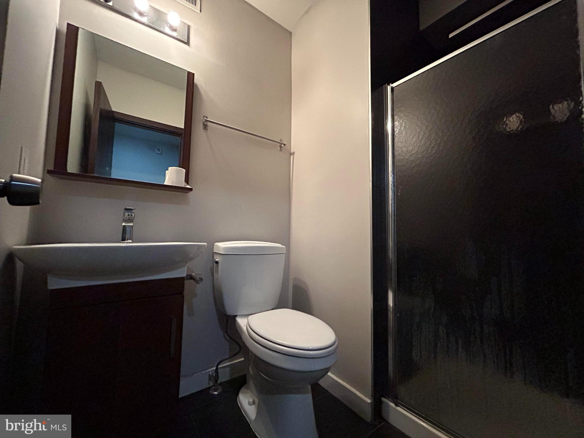 1702 North 18th Street, Unit 1 Philadelphia, PA 19121 - Photo 9 of 13 a bathroom with a toilet a sink and mirror