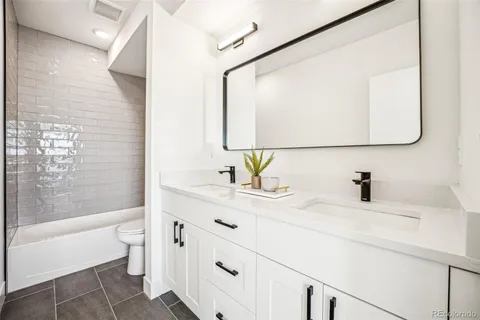 a bathroom with a bathtub sink vanity mirror and toilet