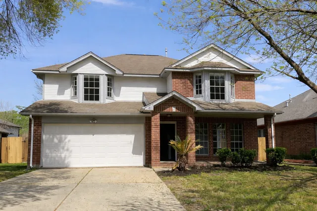 a front view of a house with yard and parking