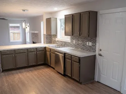 a kitchen with a sink cabinets and wooden floor