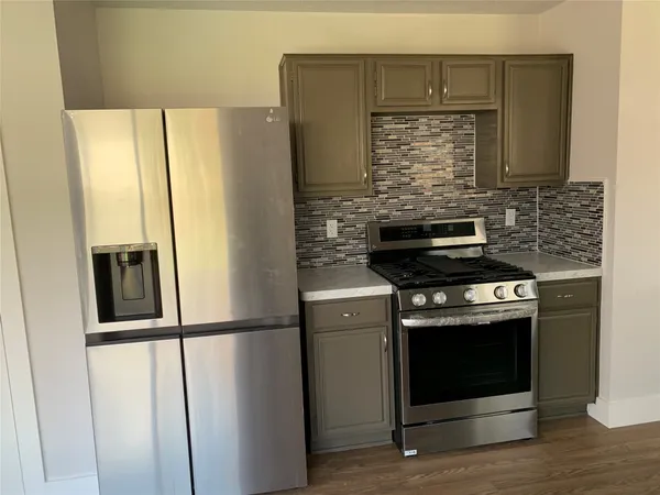 a kitchen with stainless steel appliances wooden floor sink and wooden cabinets