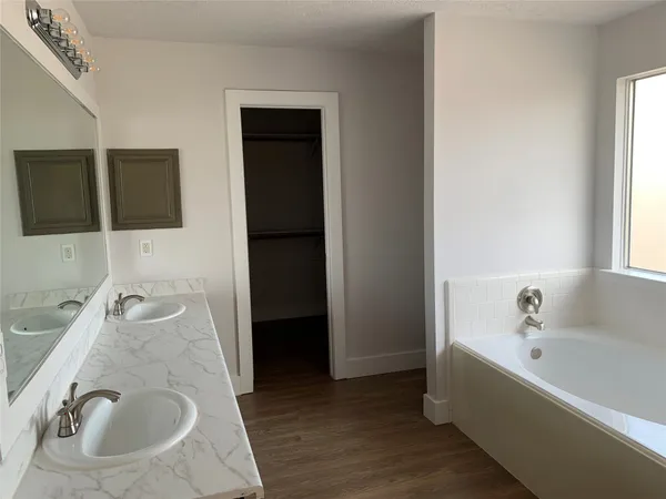 a en suite bathroom with a granite countertop tub and a sink
