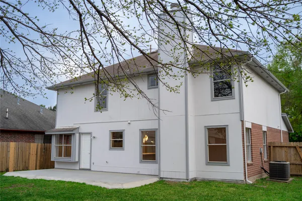 a view of a white house with a large tree