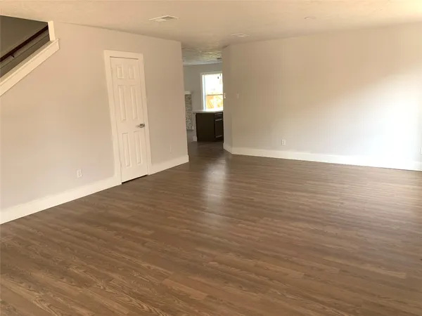 a view of a room with wooden floor and window