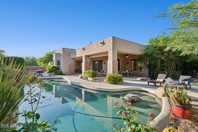a view of a house with swimming pool and sitting area