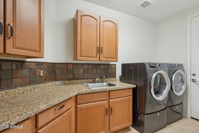 a utility room with sink dryer and washer