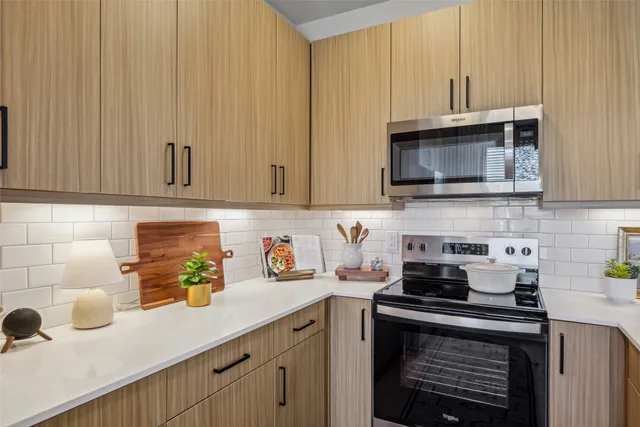 a kitchen with stainless steel appliances granite countertop a sink a stove and a microwave