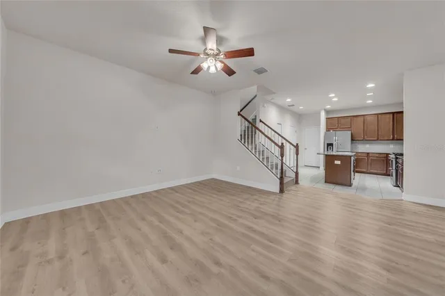 a view of a livingroom with wooden floor and staircase