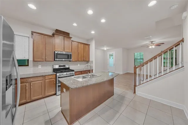 a kitchen with stainless steel appliances granite countertop a sink dishwasher stove top oven and cabinets