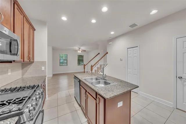 a kitchen with kitchen island a sink stove and cabinets